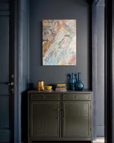 Ein Sideboard mit blaubeckischen Gefäßen und einer bunten Wandkunst über einem dunklen Hintergrund.