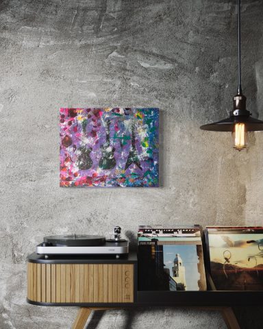 Schallplattenspieler neben einem Regal mit Schallplatten, dekoriert mit einem bunten Gemälde.