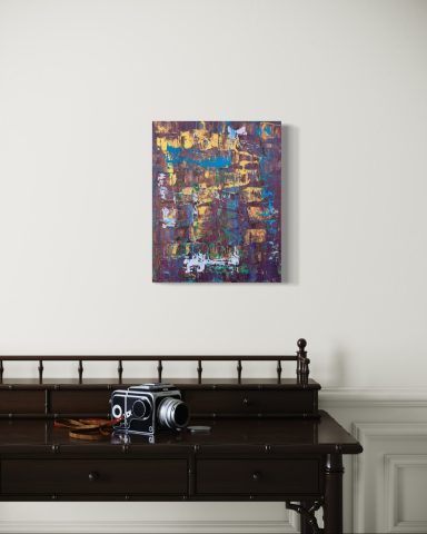 Bunter abstrakter Kunstwerk an einer Wand über einem dunklen Holzschreibtisch.